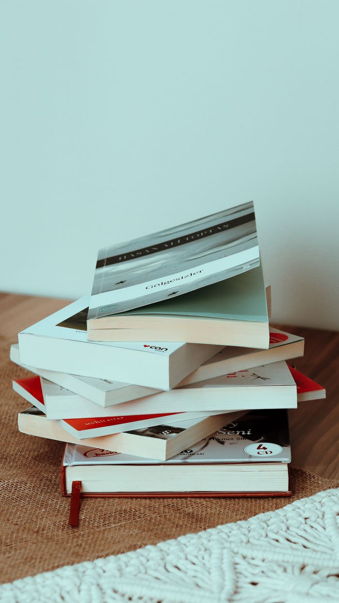 best-selling product-01 Stack of different interesting books placed on beige rug on wooden floor at home with white walls